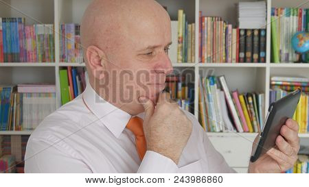 Businessman In Office Room Reading Good Financial News On Tablet
