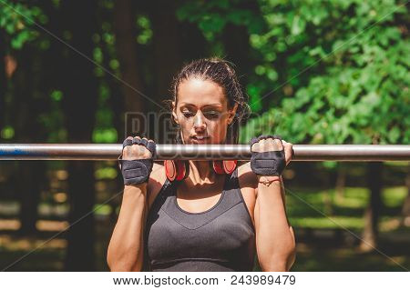 Portrait Of Fitness Woman Doing Pullups In Nature.