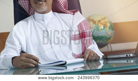 Senior Saudi Businessman Hand Writing At His Desk
