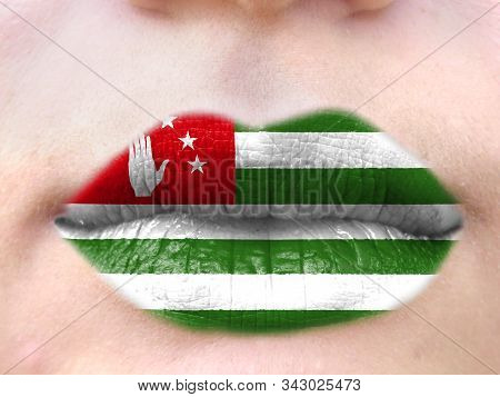 Female Lips Close Up With A Picture Flag Of Abkhazia. Learning Languages.