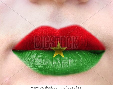 Female Lips Close Up With A Picture Flag Of Burkina Faso. Learning Languages.