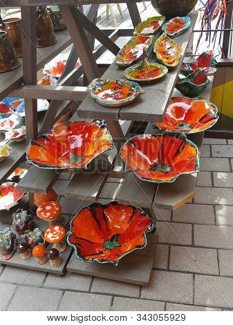 Merchandise On Open Air Tourist Souvenir Market In Riga Old Town. Bright Red And Orange Poppy Shape 