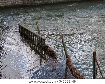 High Water Of Spring Floods Rushing Through An Old Broken Fence
