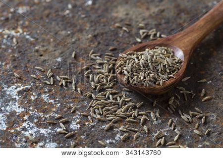Cumin Seeds In Wooden Spoon On A Textured Background