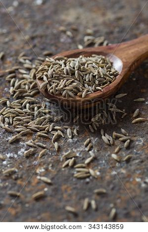 Cumin Seeds In Wooden Spoon On A Textured Background