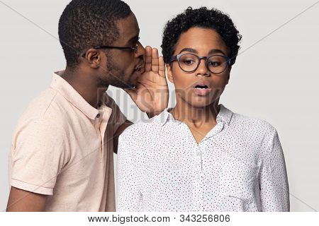 African Guy Whispering To Ear Of Girl Secret, Studio Shot