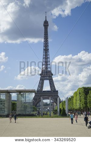 Paris, France - 6th June, 2019: Eiffel Tower View From Far. Tourists Walk Around The Sights. Vertica