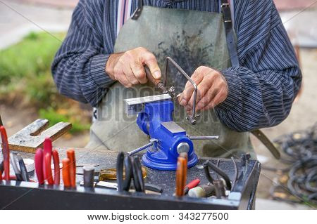 Elderly Male Working On Machine Tool For Metal. Old Man At The Workplace With Tools. Retirement Hobb