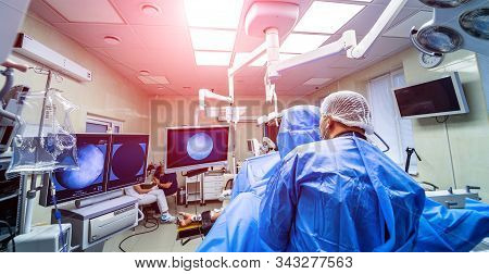 Establishing Shot Of Technologically Advanced Operating Room With Suregeons Ready For Operation. Ope