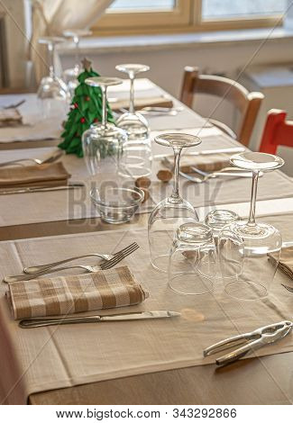 Dinner Table With A Small Christmas Tree And Sprinkled Walnuts, Selective Focus
