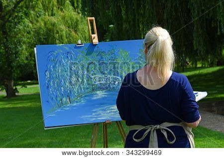 St Neots, Cambridgeshire, England - August 03, 2019: Close Up Of Young Woman Painting In The Park.
