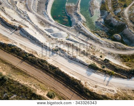 Opencast mining quarry with machinery at work - Aerial view. Industrial Extraction of lime, chalk, calx, caol