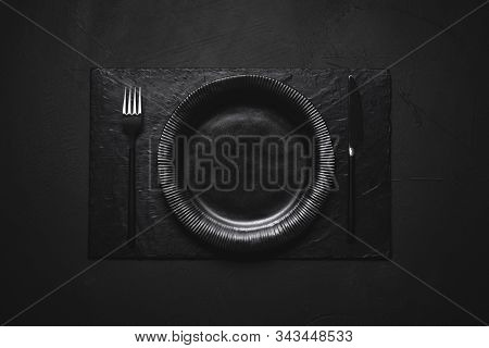 Empty Dish And Cutlery In Black Shades. Black Dinner Arrangement. Black Plate And Black Cutlery On A