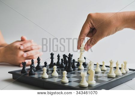 Hand Holding Chess Pieces On Board With White Background, Driven To Success Business Strategy.