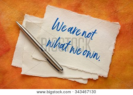 We are not what we own - inspirational handwriting on a handmade paper, simplicity, minimalism, lifestyle and anti consumerism concept