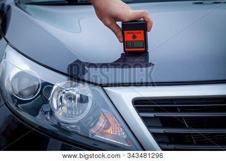 Measuring The Thickness Of The Car Paint Coating In Black Color Using A Paint Thickness Gauge.