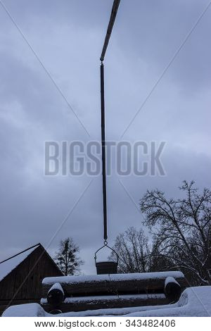 Snowy Retro Pail At The Well Is Suspended On A Lever In Winter In Open-air In Roznov Pod Radhostem I