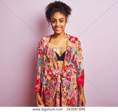 Young beautiful african american woman on vacation standing wearing bikini and colorful caftan