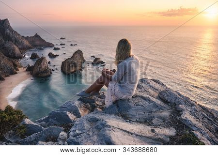 Beautiful Tourist Women Enjoying Sunset At Praia Da Ursa Beach. Surreal Scenery Of Sintra, Portugal.