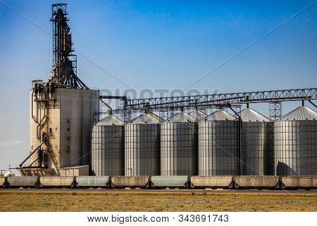A Wide Angle View Of A Grain Mill And Elevator, Group Of Steel Storage Silos Are Connected To Indust