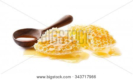 Honeycomb with honey drop on white background. Wooden spoon with wild hohey.