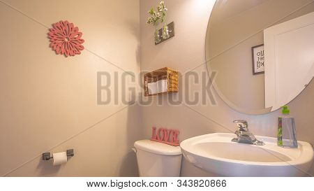 Pano Bathroom Interior With Toliet Adjacent To Stand Alone Sink And Round Mirror