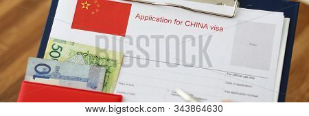 Male Hand Hold Silver Pen With Passport. Filling China Apllication Form Concept