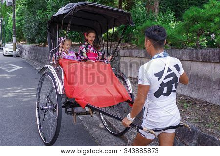 Kyoto, Japan 08.2019 Japanese Rickshaw Rides Kimano-dressed Girls.
