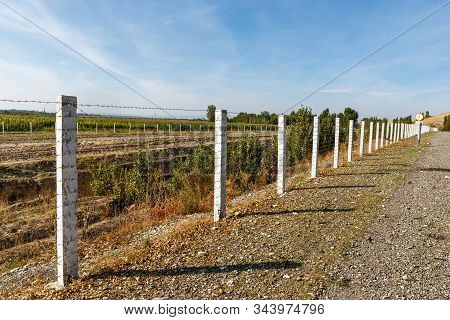 Barbed Wire Fence, State Border Between Kyrgyzstan And Uzbekistan