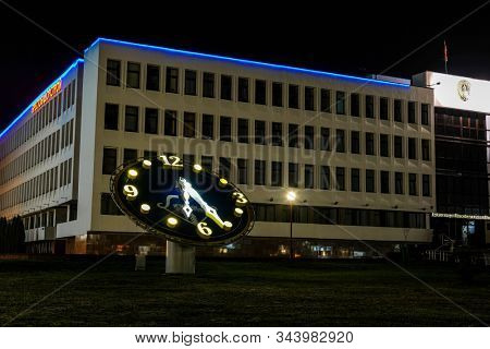 Brest, Belarus - November, 17, 2019: building in Brest at night with a clock in the foreground