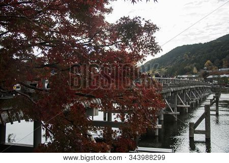 Kyoto, Japan-26 Nov, 2019: Togetsu-kyo Bridge Over Katsuragawa River With Colourful Forest Mountain 