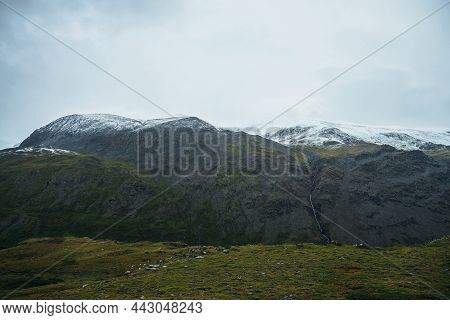 Minimalist Alpine Landscape With Snowy Mountains In Low Cloud In Overcast Weather. Deep Gorge On Bac