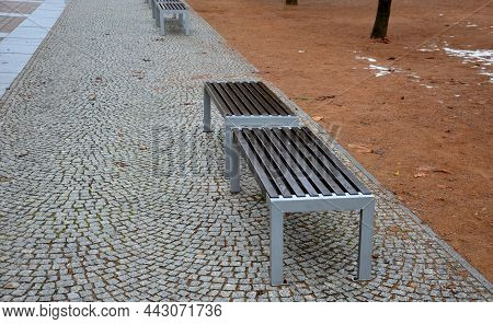 Stone Walkways To The Park Also Serving As A Place Where There Are Benches To Sit. Gray Granite Cube