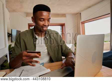 Happy Young Adult Black Male Online Shopping On Laptop In Modern Apartment.