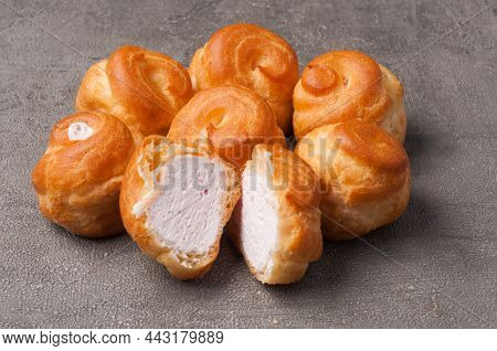 Tatsy Sweet Delicacy Profiteroles With Cream On A Gray Background