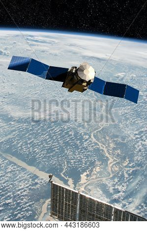 Cargo Space Craft And Earth Planet. Dark Background. Sci-fi Wallpaper.space Station Orbiting Earth.s