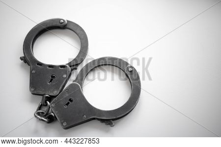 Metal Handcuffs Of A Policeman On A White Isolate. A Clean Place For Text. Arrest Of The Suspect. Cr