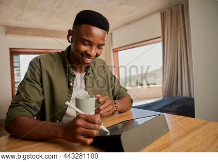 Young Adult Black Male, Holding Morning Coffee, Smiling. Writing With Pen On Electronic Tablet. Work