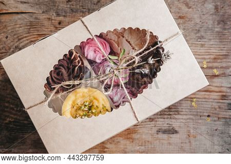 Closed Box With Different Cakes Wrapped With Thread, On A Wooden Background. Assorted Cakes In A Cra