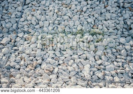 Granite Stones Behind A Metal Grate For Strengthening The Slope. Stones Behind The Wire. Grey Textur