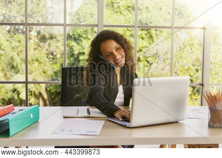 Portrait Of A Hospitable African American Business Woman Talking On A Mobile Phone With A Customer A