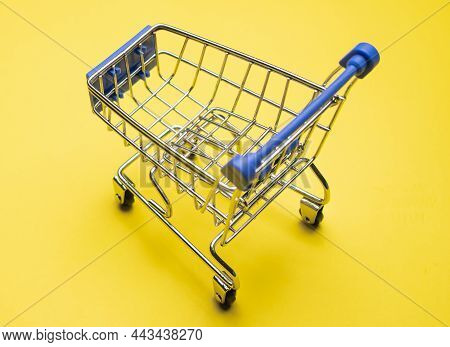 Shopping Cart On Yellow Background. Minimalism Style. Creative Design. Copy Space. Shop Trolley At S