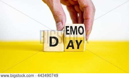 Demo Day Symbol. Businessman Turns A Wooden Cube With Concept Words 'demo Day' On A Beautiful Yellow