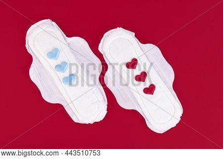 Three Blue And Red Hearts As A Symbol Of Transgender, Menstrual Cycle On A Feminine Sanitary Napkin.