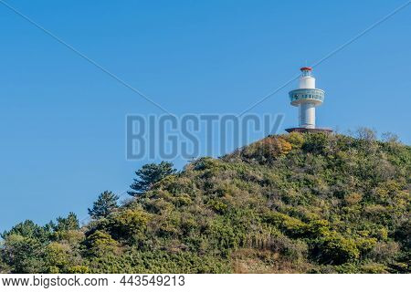 Observation Tower On Hill Of Lush Green Foliage With Clear Blue Sky In Background.