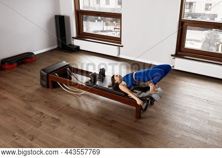 The Instructor Does Exercises On The Reformer, A Beautiful Girl Trains On The Modern Reformer Simula