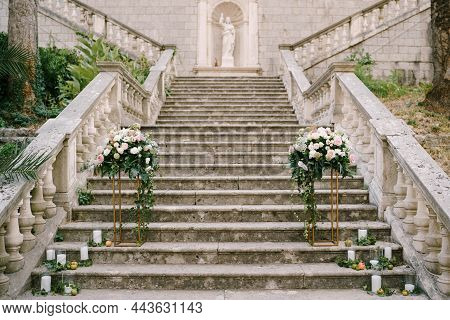 Wedding Semi-arch Of Roses On Pedestals Stands On The Stone Steps Of An Ancient Church