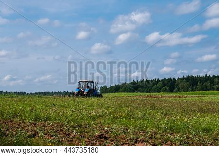 Tractor Working In The Field, Plowing The Land, Preparing For Sowing. View Of The Field And Tractor 