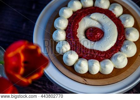 The Baked Cake Cake Lies On A Wooden Substrate And On A White Stand, The Cake Is Decorated With Whit