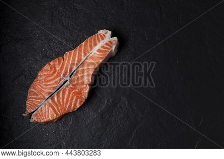 Raw Salmon Steak On A Black Textured Background. Copy Space.